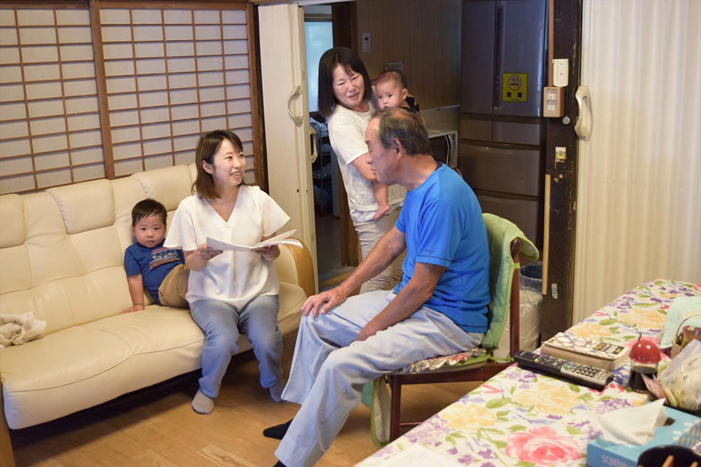 宿のリビングでノートを見せてもらった時の様子。隣のキッチンで、自炊もできるようになっている。